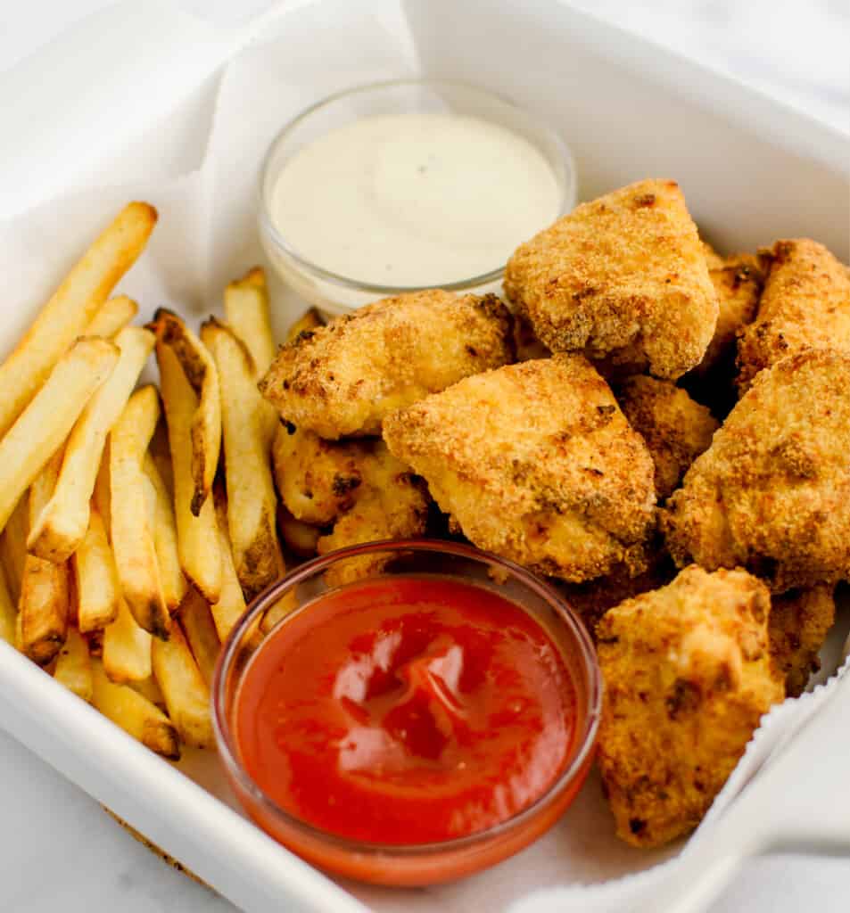 Golden Chicken Nuggets with Fries, Ketchup, and Ranch in White Dish