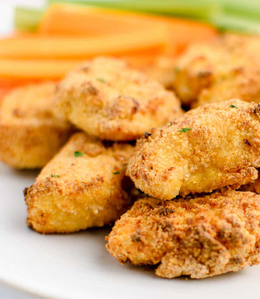 Golden Brown Chicken Nuggets with Veggies in the Background