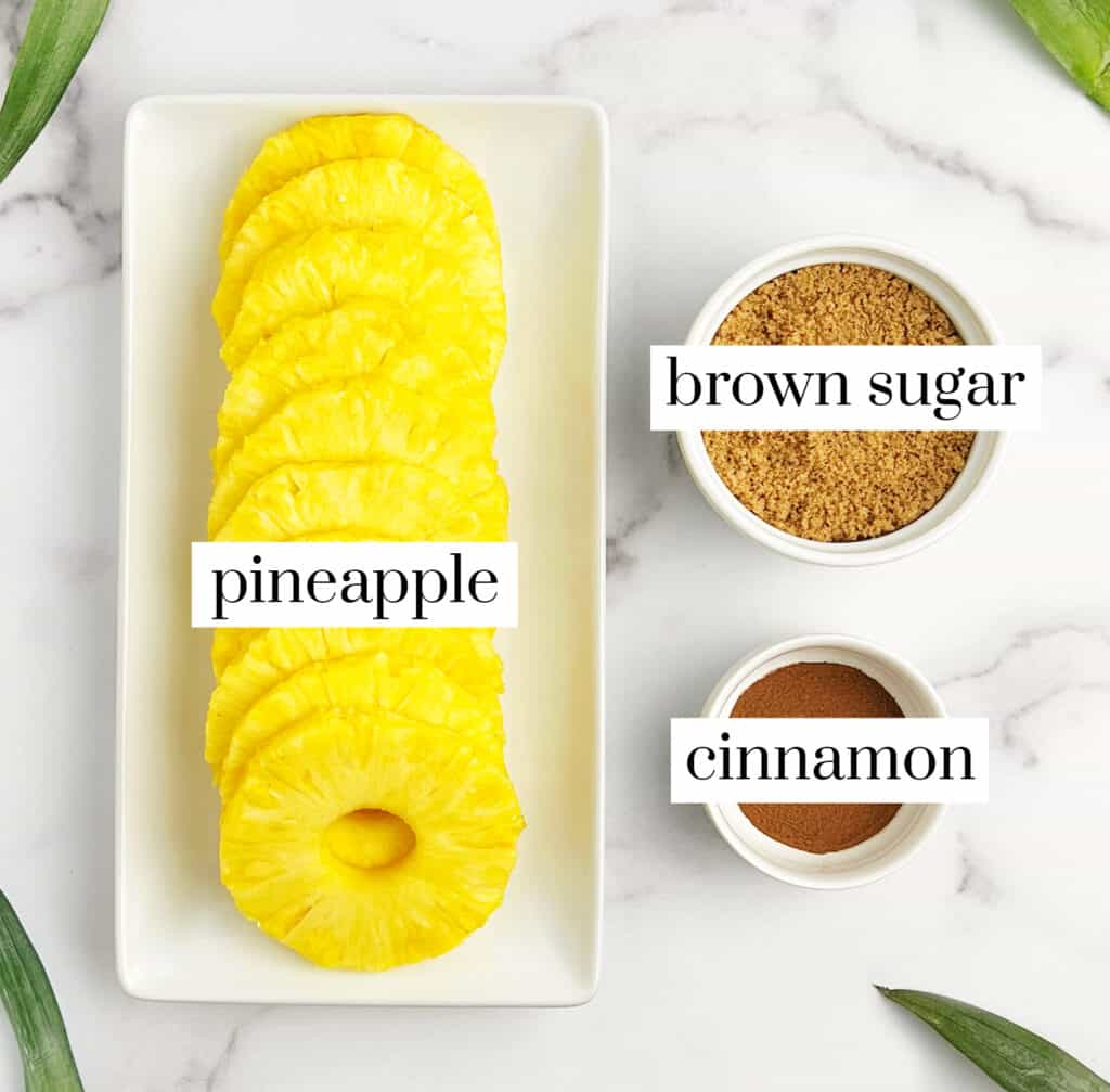 Pineapple Rings on White Serving Plate, Brown Sugar and Cinnamon in Small White Bowls on a White Marble Countertop