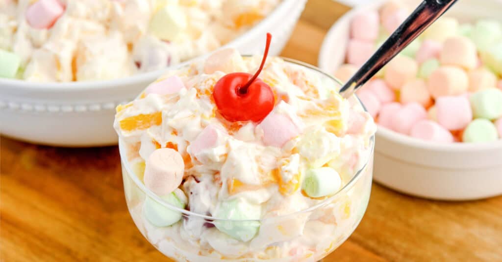 Ambrosia Salad in Glass Bowl with Cherry and Spoon