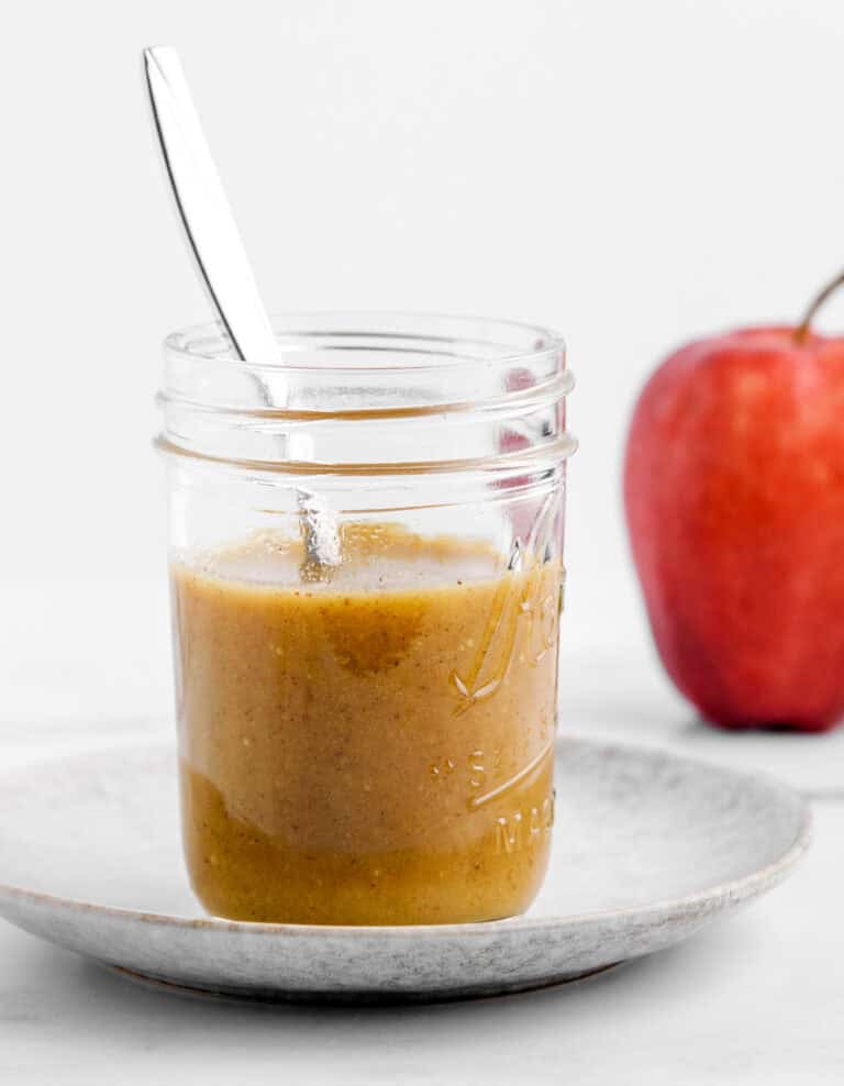 Apple Cider Vinaigrette in Mason Jar with Spoon and Apple in the Back