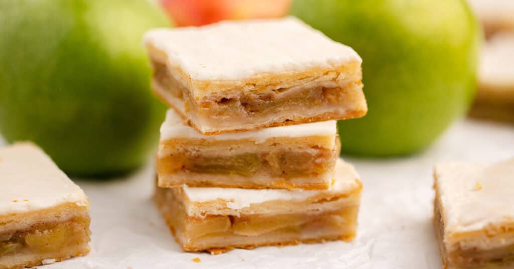 Apple Pie Bars Stacked with Green Apples Behind