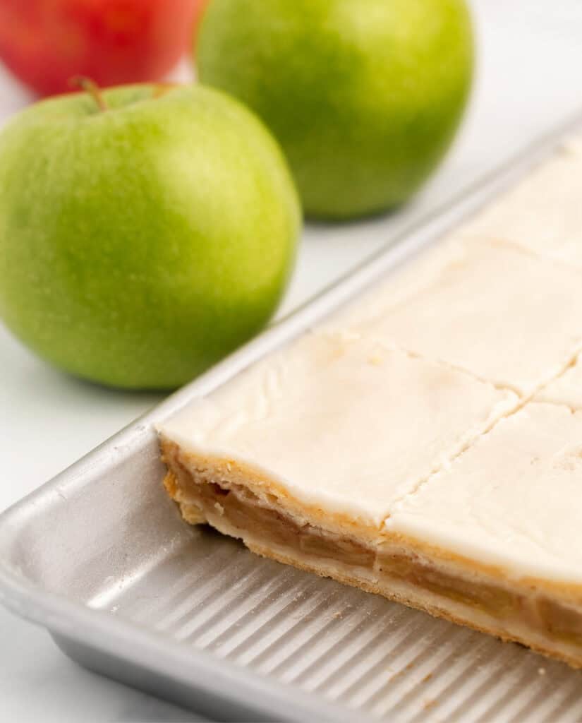 Apple Pie Bars in Pan Before Cutting with Green Apples in the Background