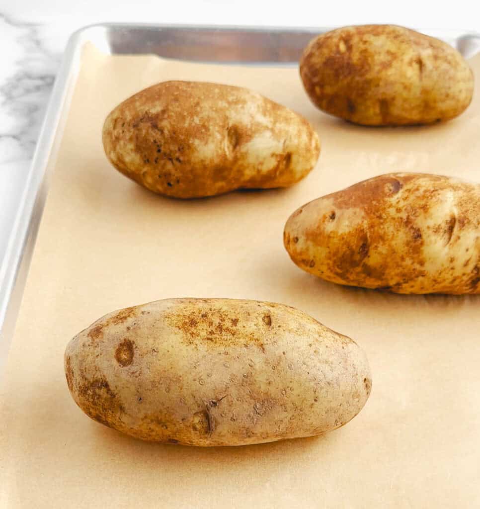 Raw Potatoes on a Baking Sheet with Parchment