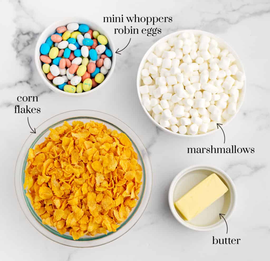 Bowls of Corn Flakes, Marshmallows, Butter, and Whopper Robin Egg Candy on White Marble Surface