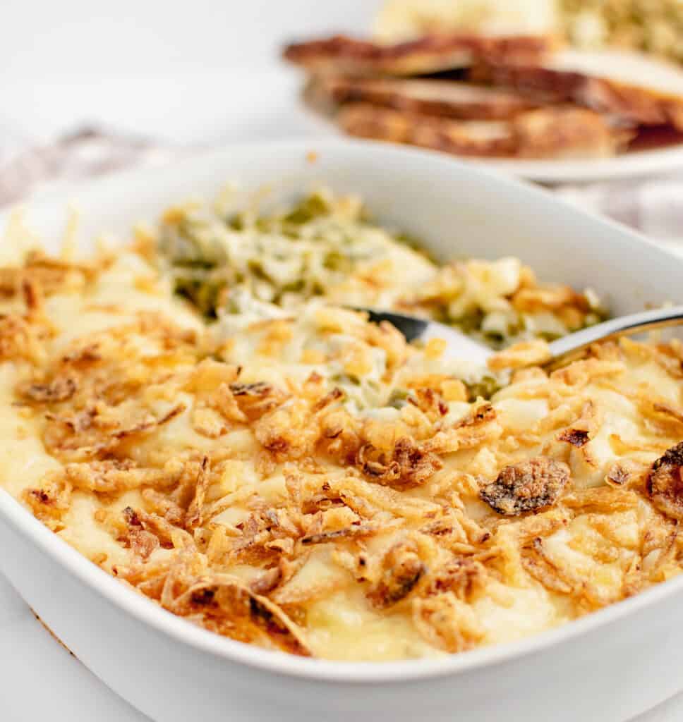 Taking a Scoop Out of Green Bean Casserole with Cheese with a Spoon