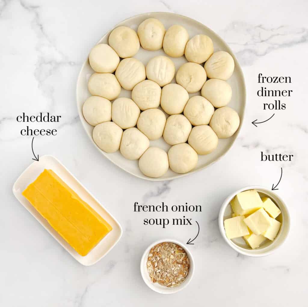Rolls Dough, Cheese, Butter, and French Onion Mix on White Marble Surface
