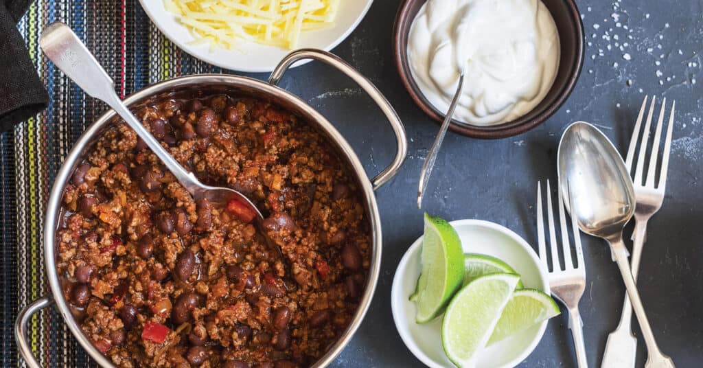 Pot of Chili with Chili Toppings and Utensils