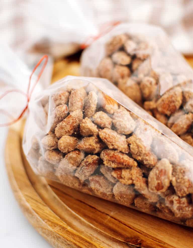 Cinnamon Roasted Almonds in Plastic Bags Tied with Red String on Wooden Surface