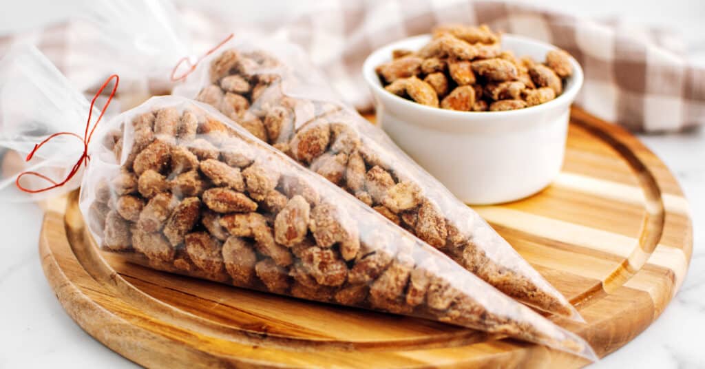 Cinnamon Roasted Almonds in Plastic Bags Tied with Red String on Wooden Surface