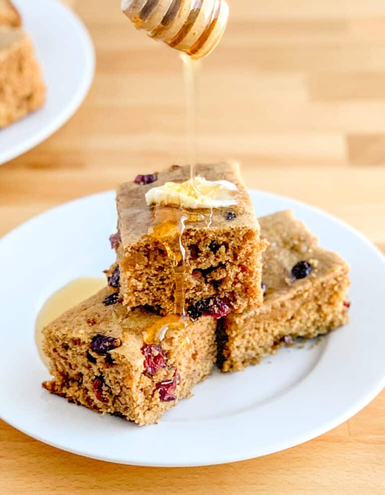 Cranberry Cinnamon Cornbread on Plate with Honey Drizzle and Butter
