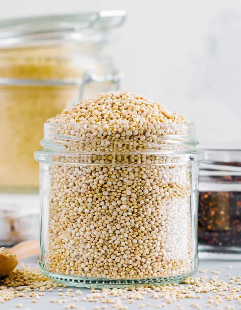 Raw Quinoa in a Glass Jar with Quinoa on the Countertop