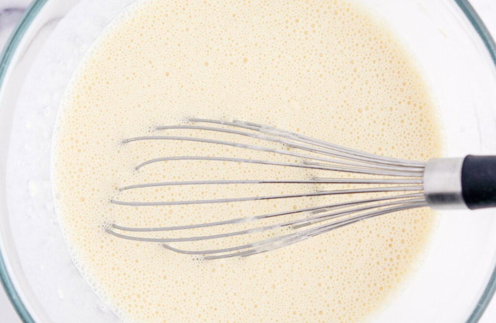 Final Crepe Batter in Glass Bowl with Whisk