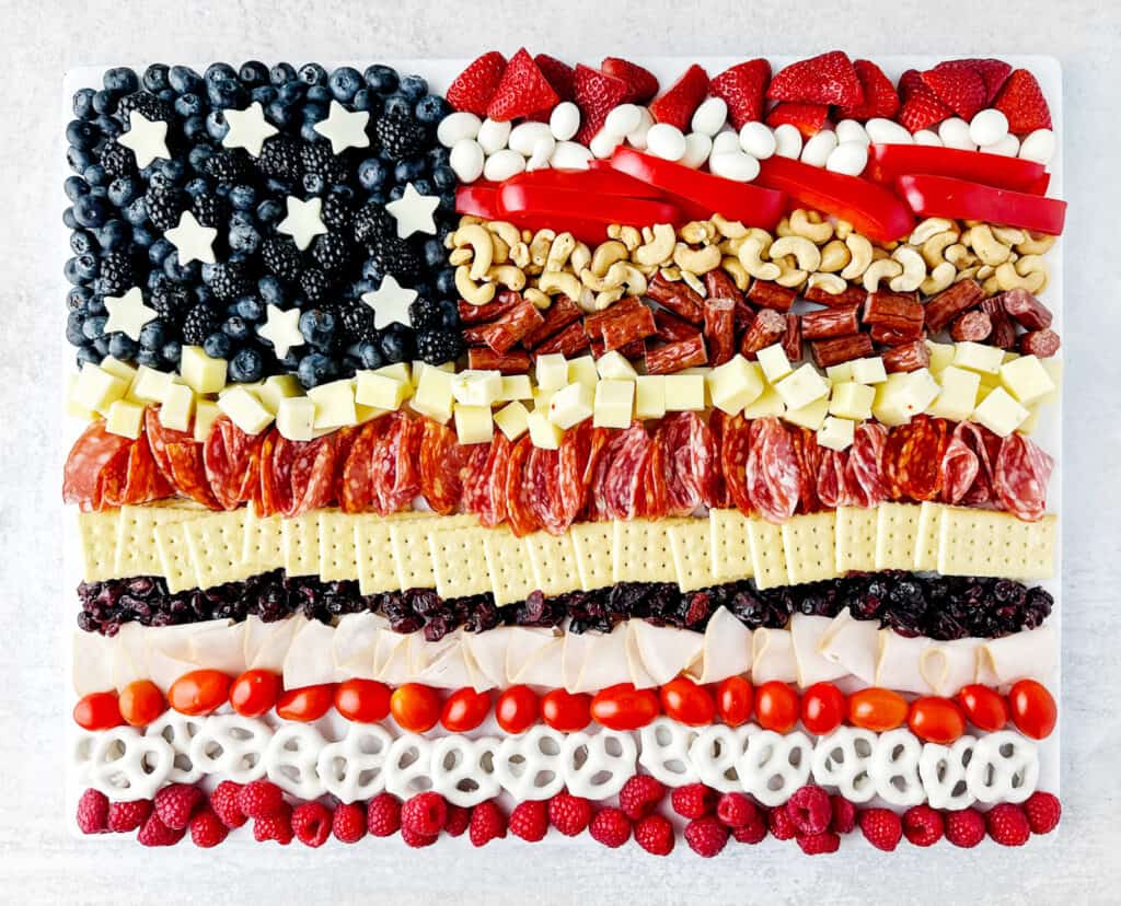 Full Top Down View of Flag Charcuterie with Blueberries and White Cheese Stars with Rows of Red and White Foods