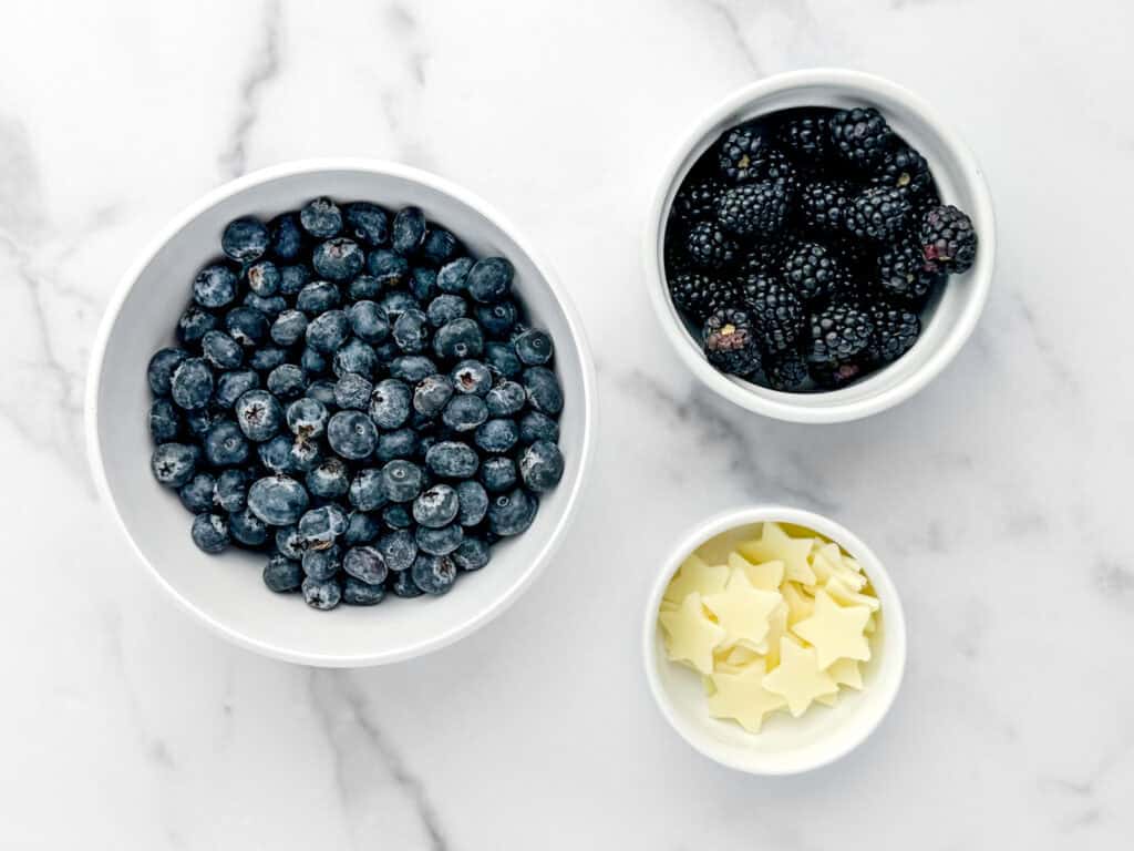 Blue Ingredients in White Bowls on Marble Surface (Blueberries, Blackberries, Cheese Starts)