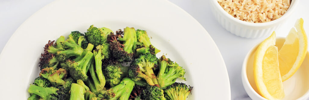 Crisp Broccoli on White Plate with Rice and Lemon