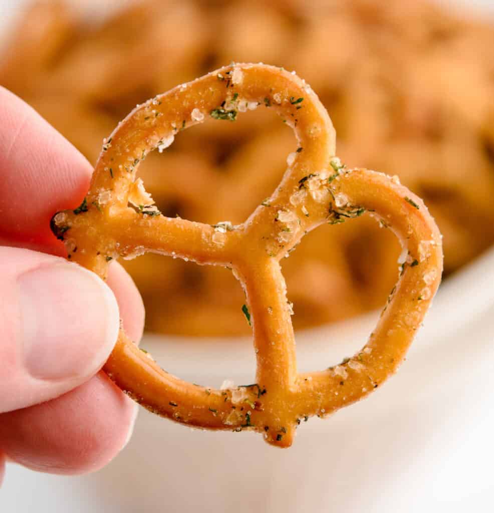Hand Holding Ranch Pretzel with Bowl of Pretzels in the Background