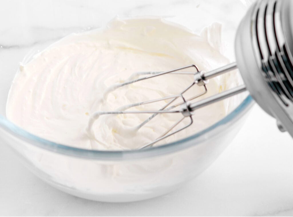 Hand Mixer in Glass Bowl with Blended Sour Cream and Cream Cheese