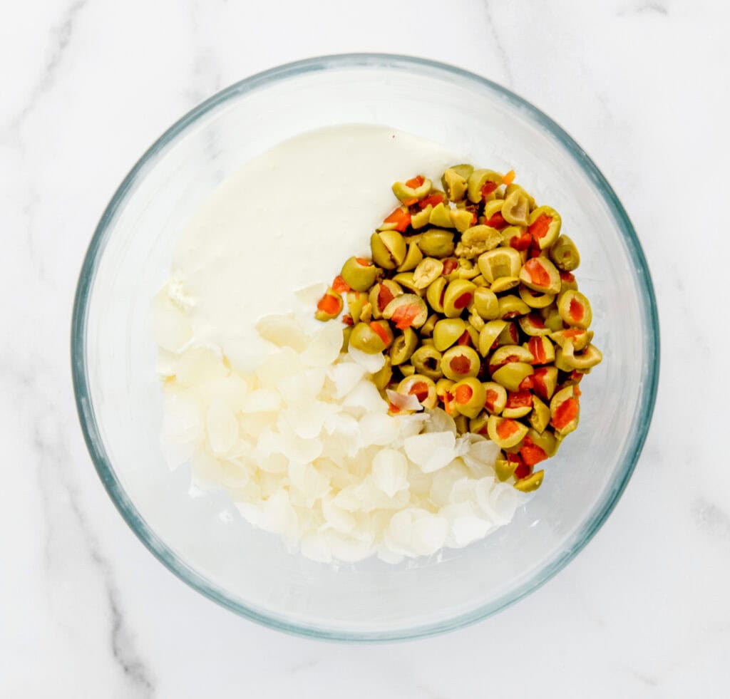 Green Olives, Onions, and Cream Cheese Mixture in Bowl Before Being Mixed
