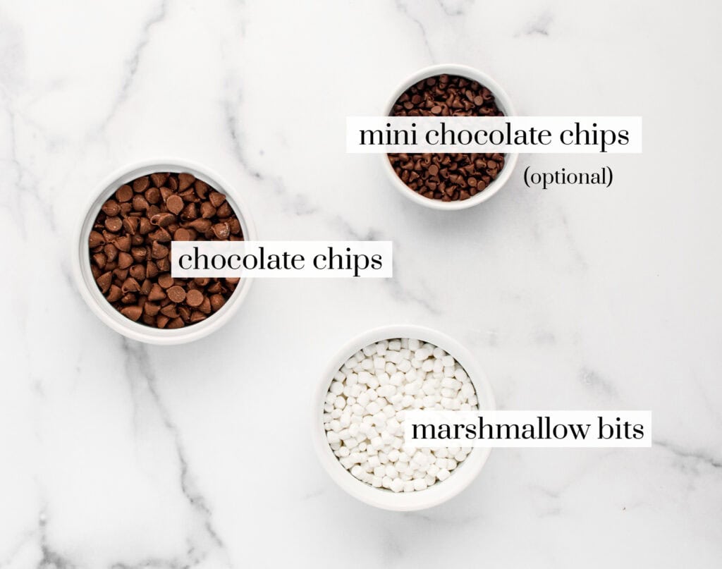 Chocolate Chips, Marshmallow Bits and Mini Chocolate Chips in Bowls on White Marble Surface
