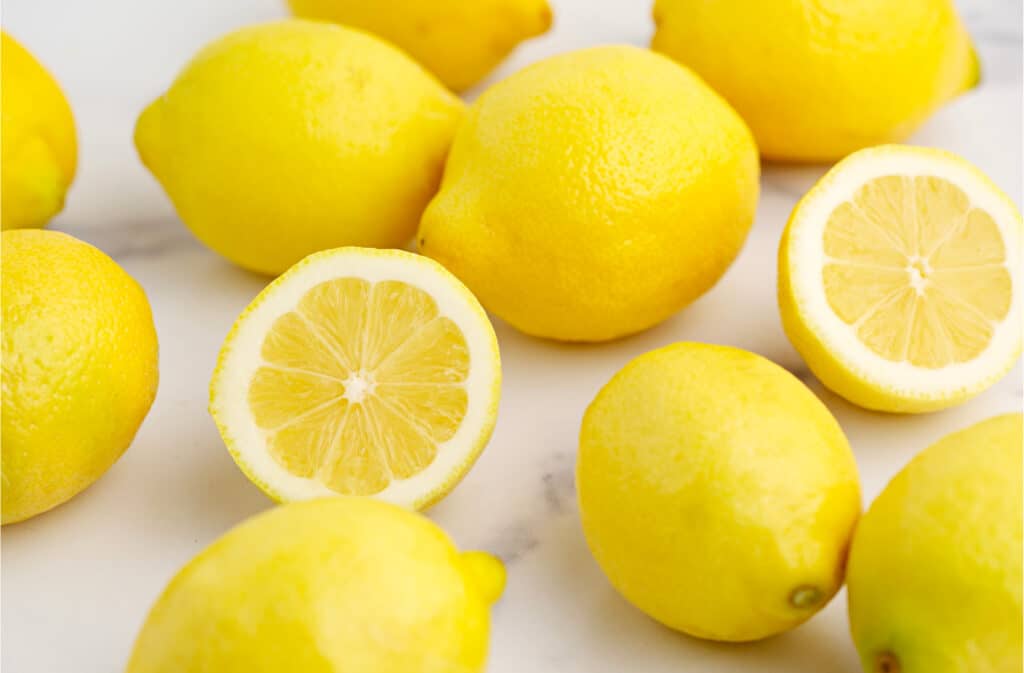 Whole and Half Lemons on Marble Surface