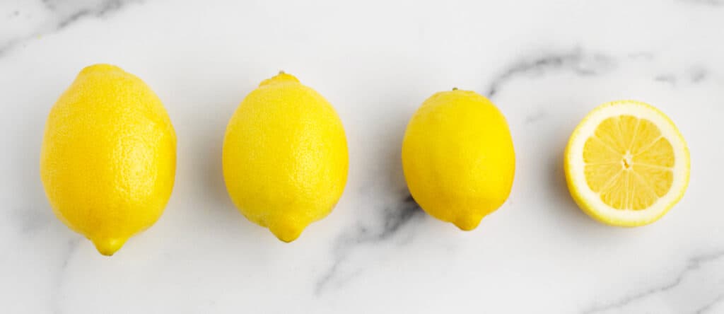 Different Sizes of Lemon Large, Medium, Small, and Half Lemon on White Marble Surface