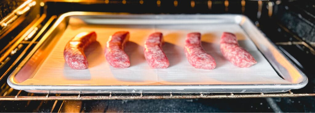 Fresh Brats on Baking Sheet on Oven Rack