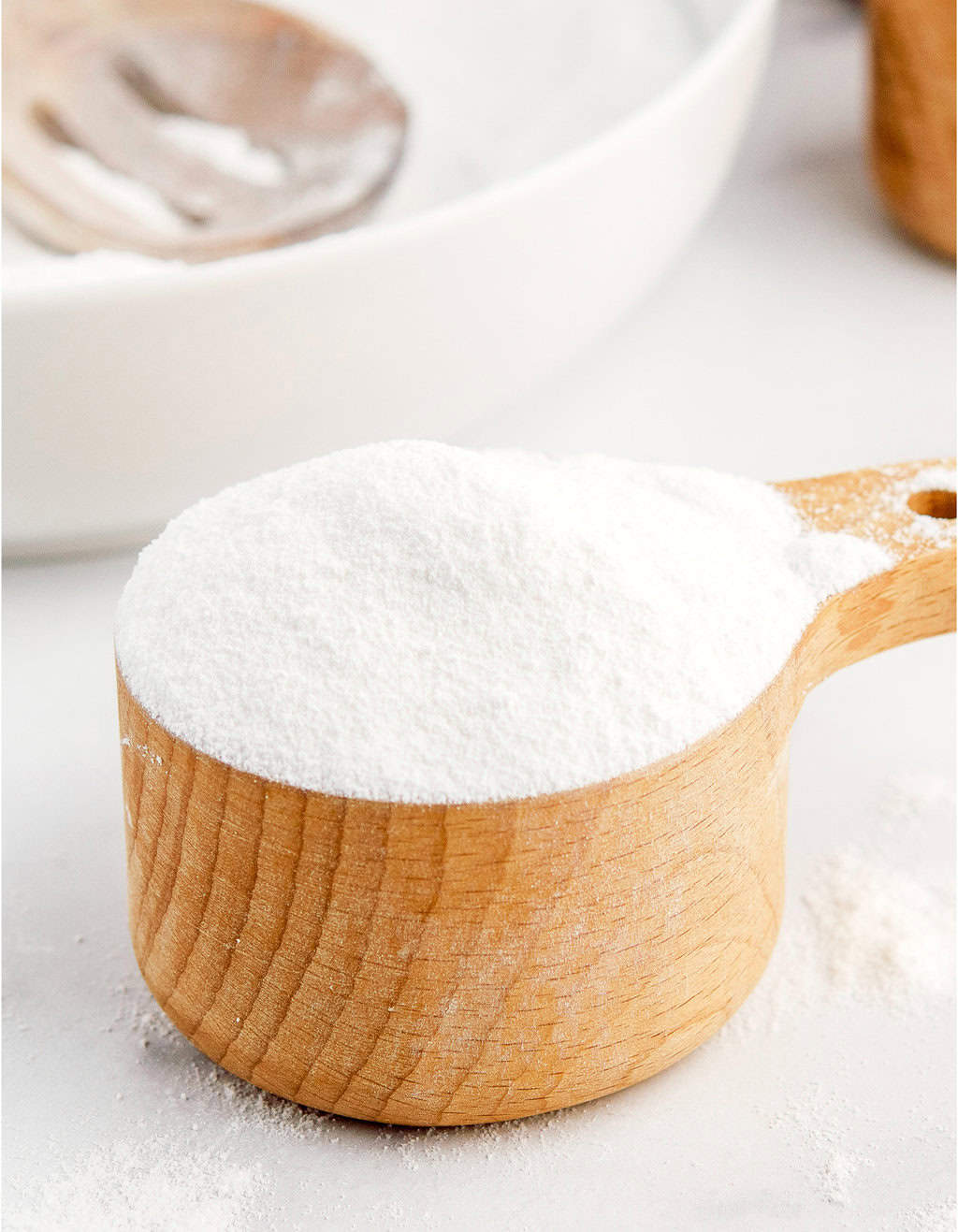 Powdered Sugar in Wooden Measuring Cup