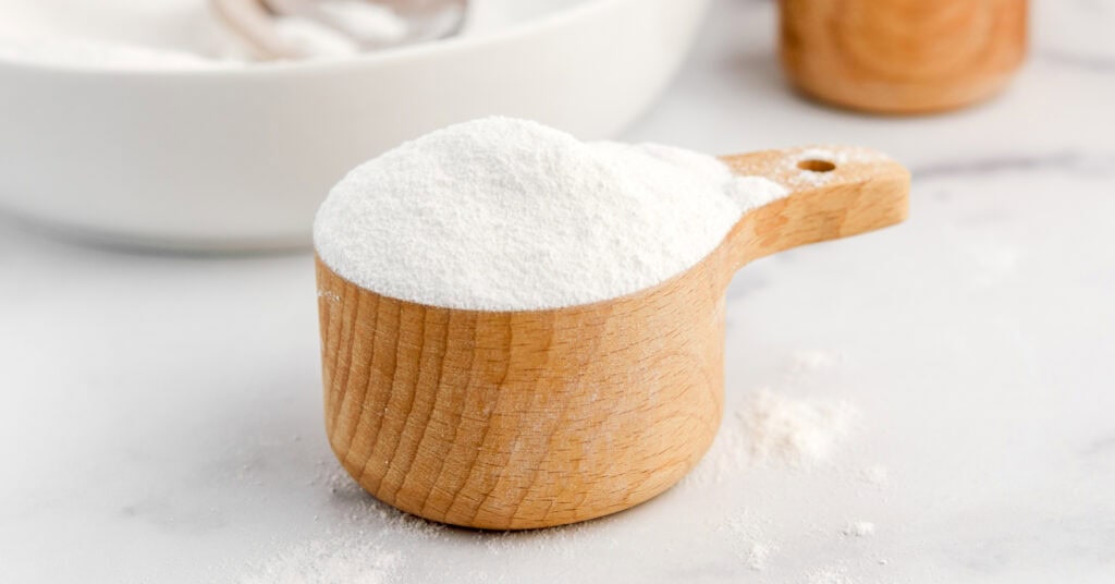 Powdered Sugar in Wooden Measuring Cup