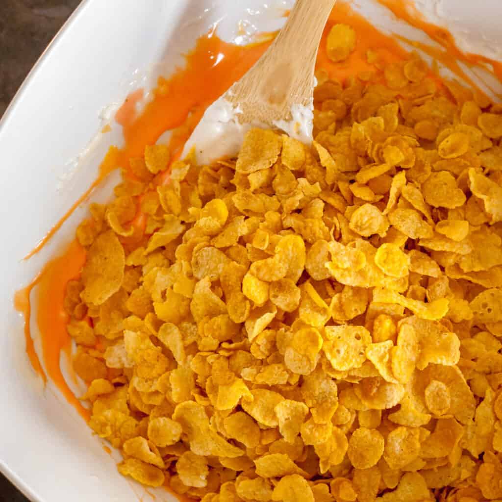Corn Flakes in Bowl with Orange Melted Marshmallow Mixture