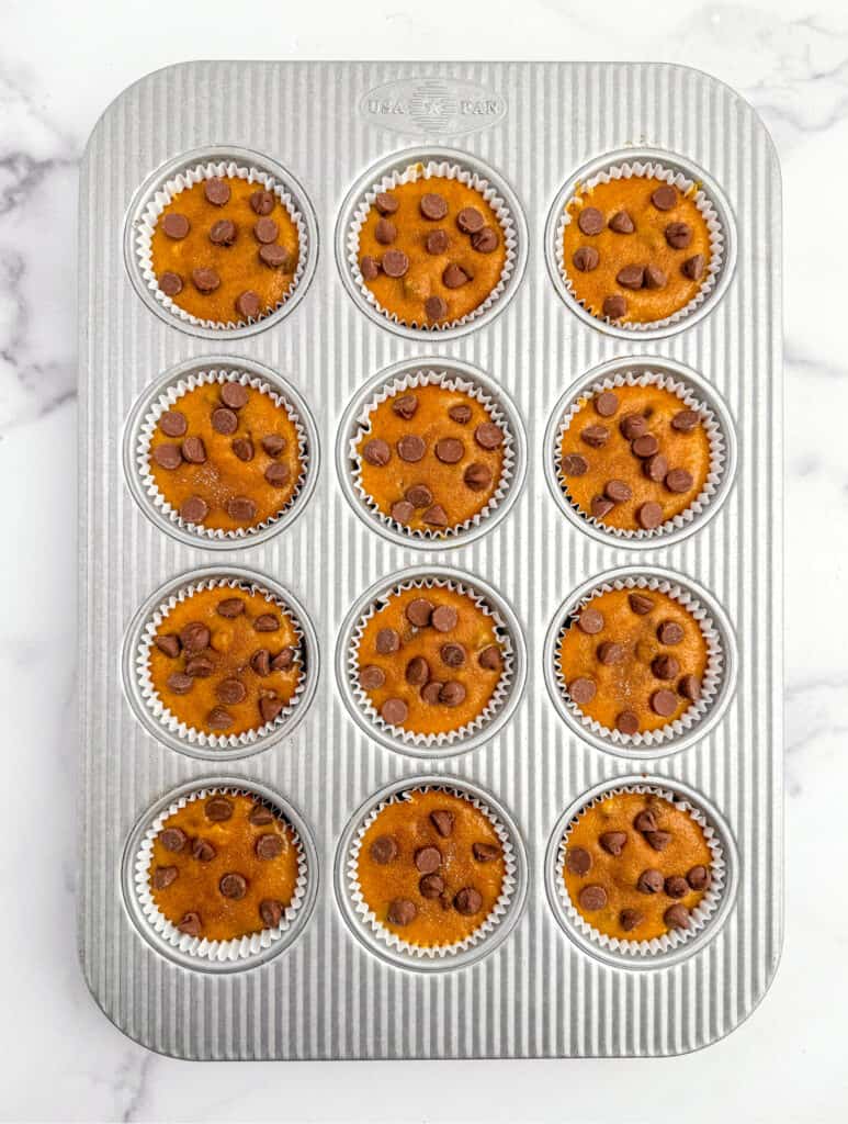 Adding Toppings to Pumpkin Muffin Batter in Muffin Tin