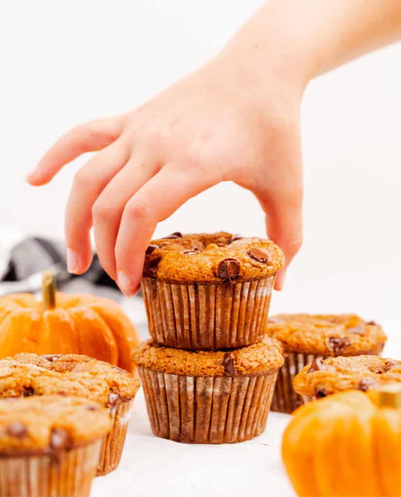 Hand Grabbing Pumpkin Muffin from Stack