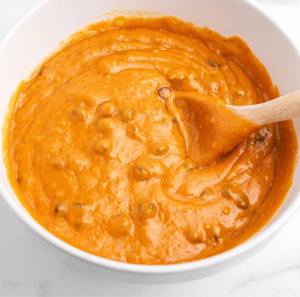 Pumpkin Muffin Batter Finished in White Bowl with Wooden Spoon