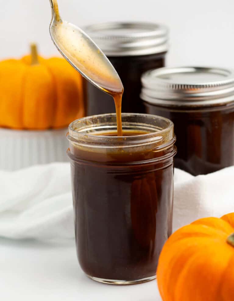 Pumpkin Spice Syrup in a Mason Jar with Small Pumpkins in Background