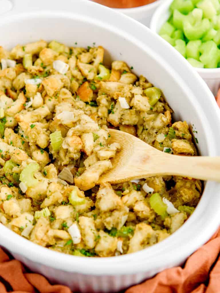 Sage and Onion Stuffing in White Dish with Wooden Spoon