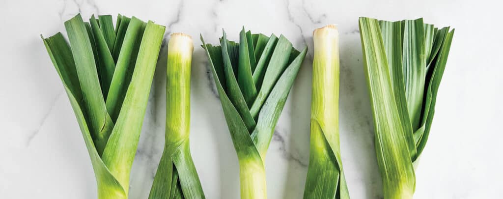 Five Leeks Alternating on White Marble Countertop