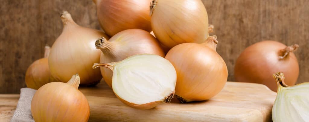 Yellow Onions on a Cutting Board with One Sliced Open