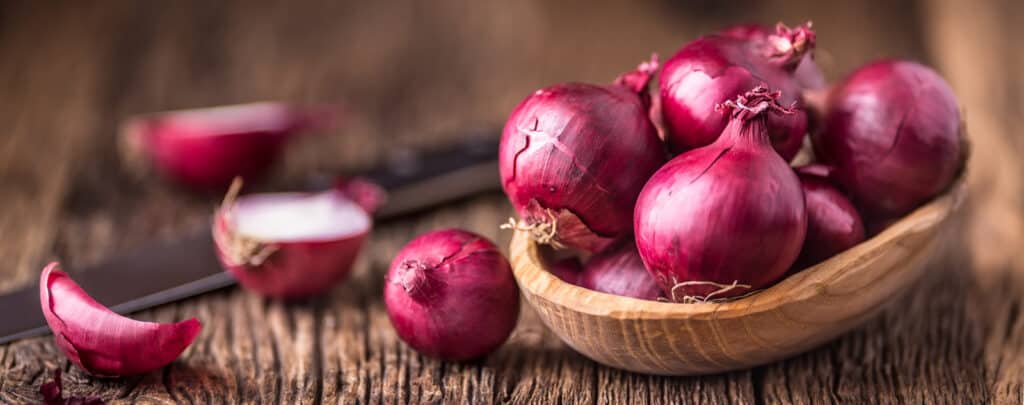 Red Oninos in a Basket and Wooden Countertop