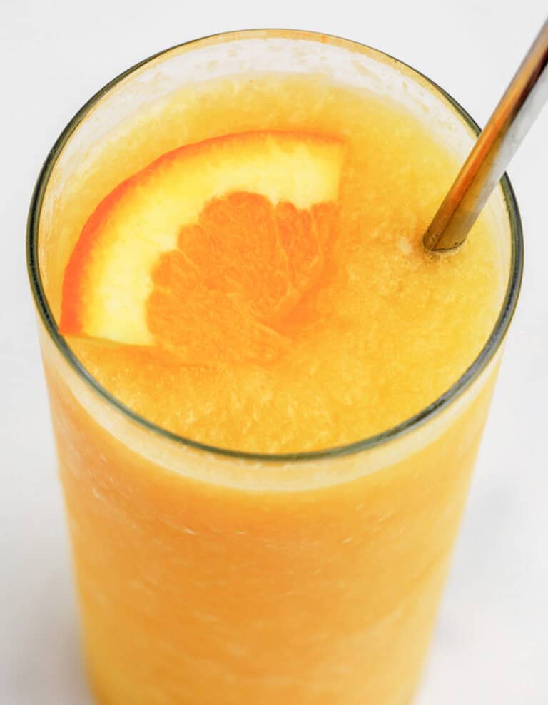 Sunrise Slush in Glass with Straw and Orange Wedge
