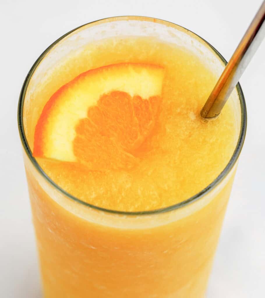 Sunrise Slush in Glass with Straw and Orange Wedge