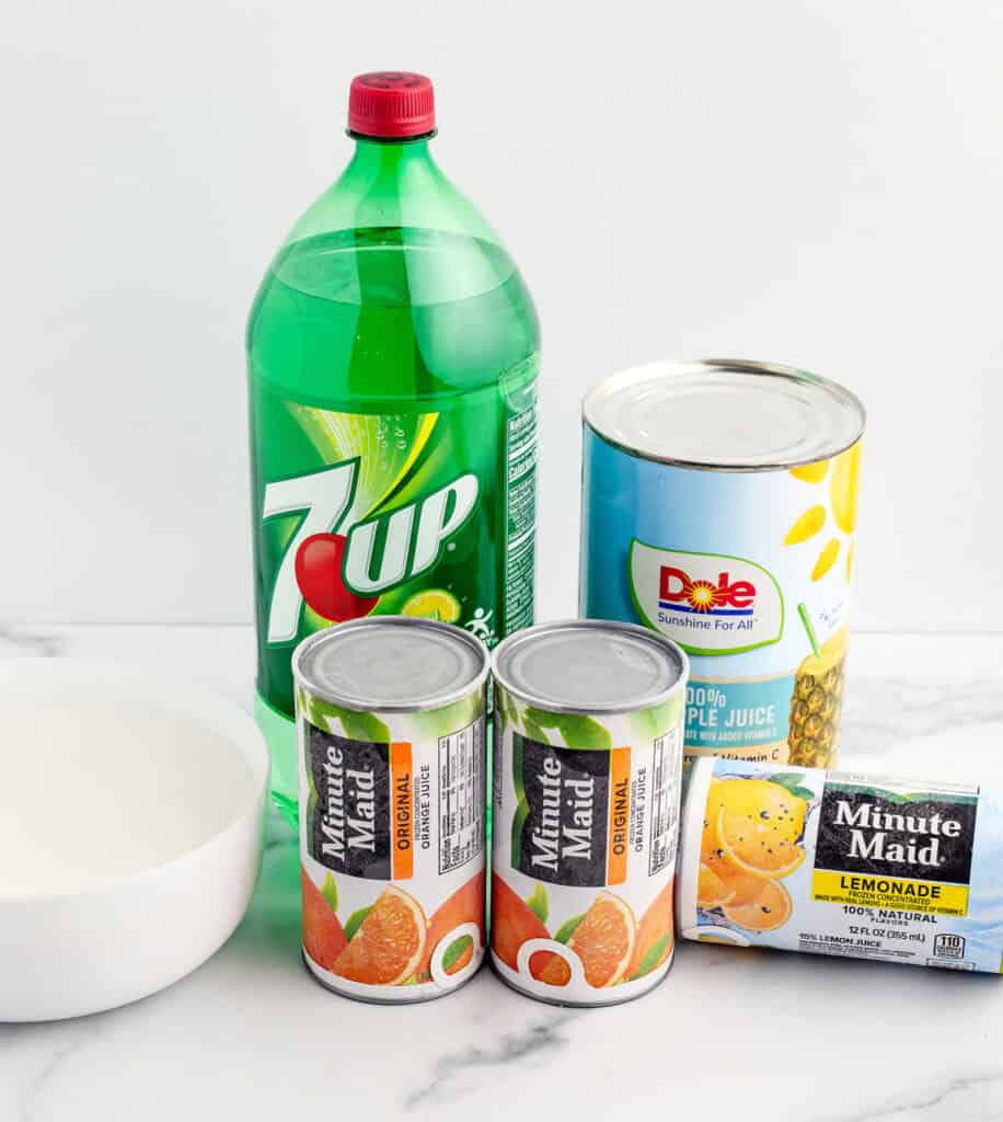 Lime Soda, PIneapple Juice, Orange Juice, Lemonade, and Sugar in Packaging on White Marble Surface