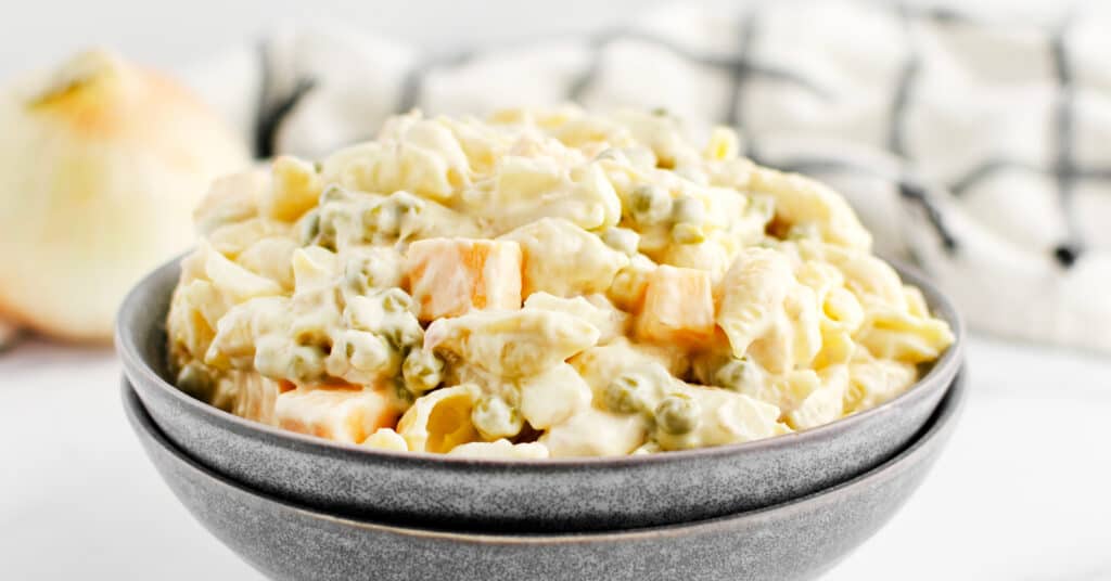 Tuna Pasta Salad in Stone Grey Bowls with Onion and Kitchen Towel Behind