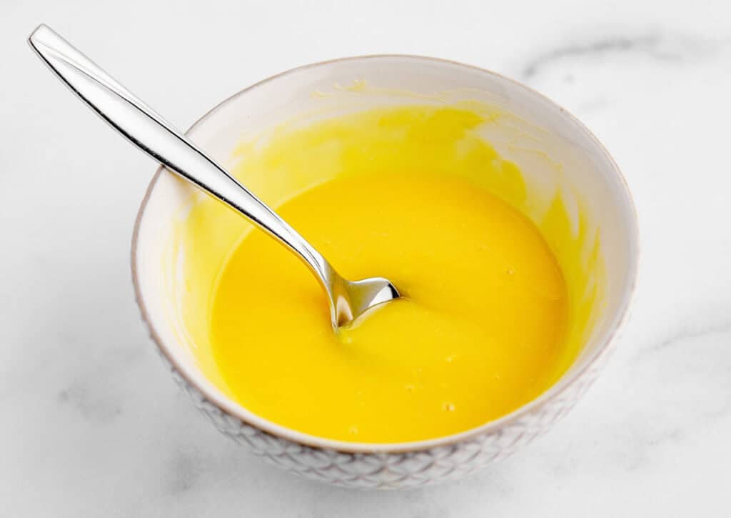 Orange Juice Pudding Mixture in Bowl with Spoon